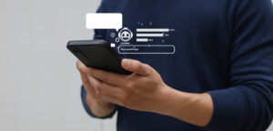 Eine Person hält ein Smartphone in den Händen, während darüber digitale Symbole, Ladebalken und ein Chatbot-Symbol eingeblendet sind.