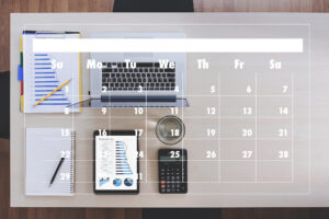 Digitale Kalenderverwaltung im Schulmanagement: Laptop, Tablet, Notizblock und Kalenderansicht auf Schreibtisch