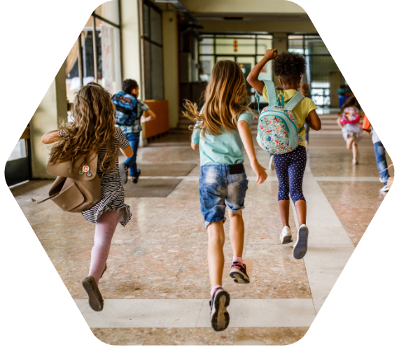 Grundschulkinder rennen fröhlich durch den Schulflur – Lernen, Gemeinschaft und Schulalltag in der Grundschule.