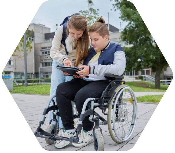 „Schülerin hilft einem Mitschüler im Rollstuhl beim Arbeiten mit einem Tablet – Inklusion und digitales Lernen an der Schule.