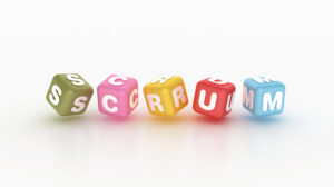 Bunte Würfel mit weißen Buchstaben bilden das Wort „SCRUM“.