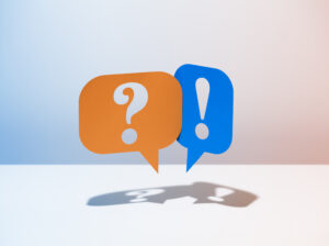 Orange Sprechblase mit Fragezeichen und blaue Sprechblase mit Ausrufezeichen vor hellem Hintergrund.