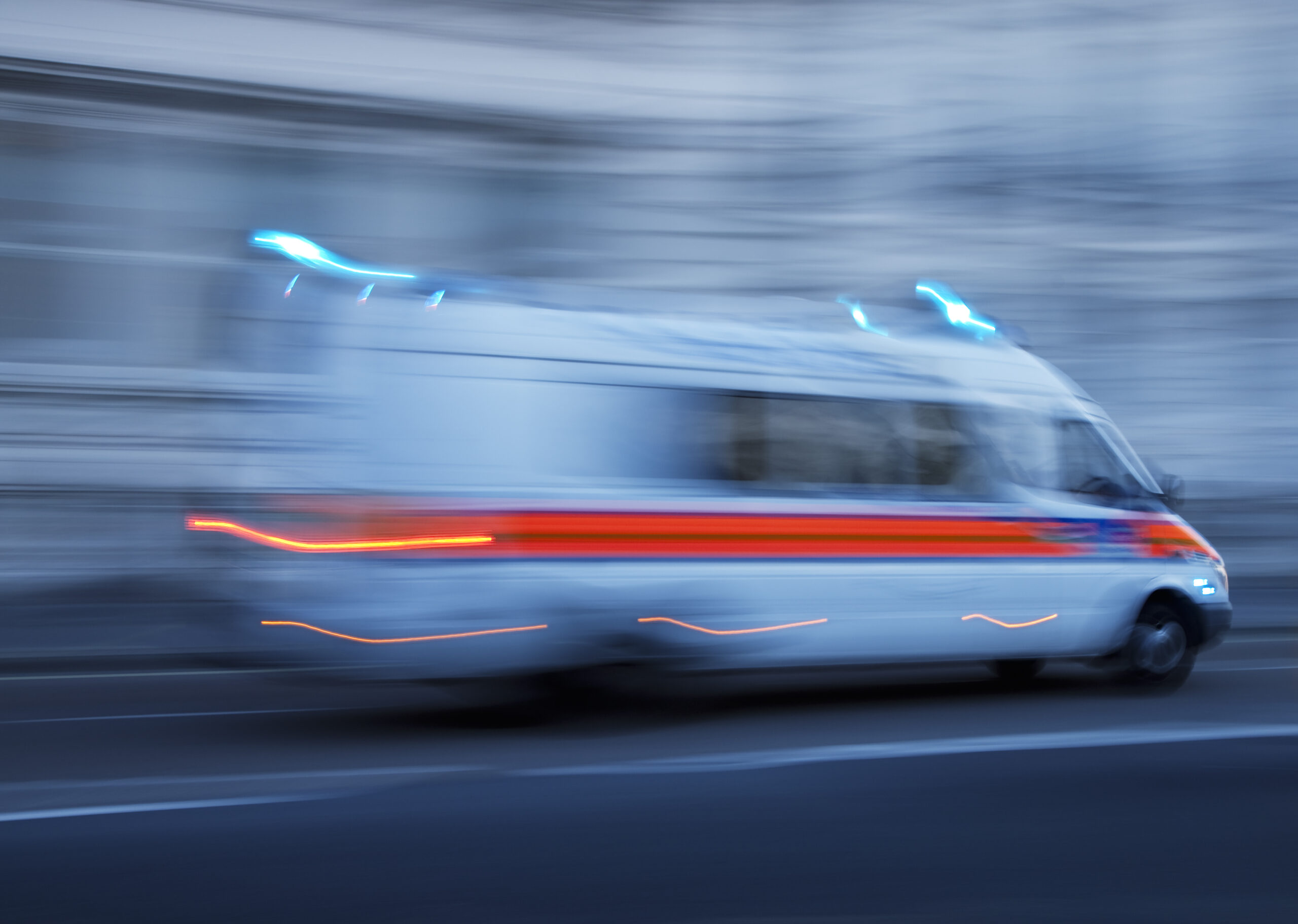 Rettungswagen mit Blaulicht in schneller Fahrt – symbolisiert einen Notfall und die Dringlichkeit von Hilfeleistung Rettungswagen mit Blaulicht in schneller Fahrt – symbolisiert einen Notfall und die Dringlichkeit von Hilfeleistung