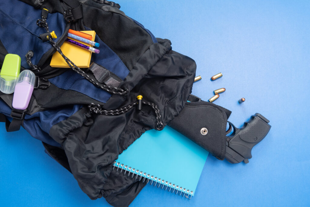 Rucksack mit Schulsachen und einer Waffe