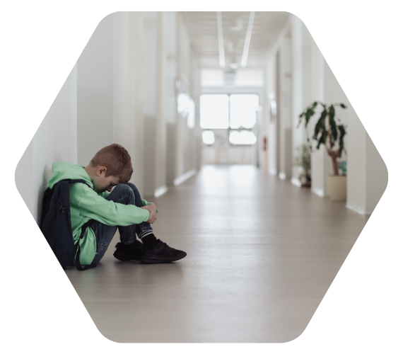 Trauriger Schüler sitzt allein im Schulflur