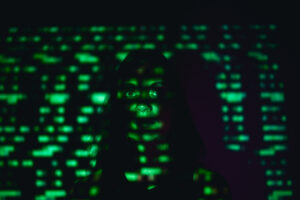 Symbolbild für Cybermobbing: Das Gesicht eines traurigen Mädchens im grün leuchtenden Cyberspace.