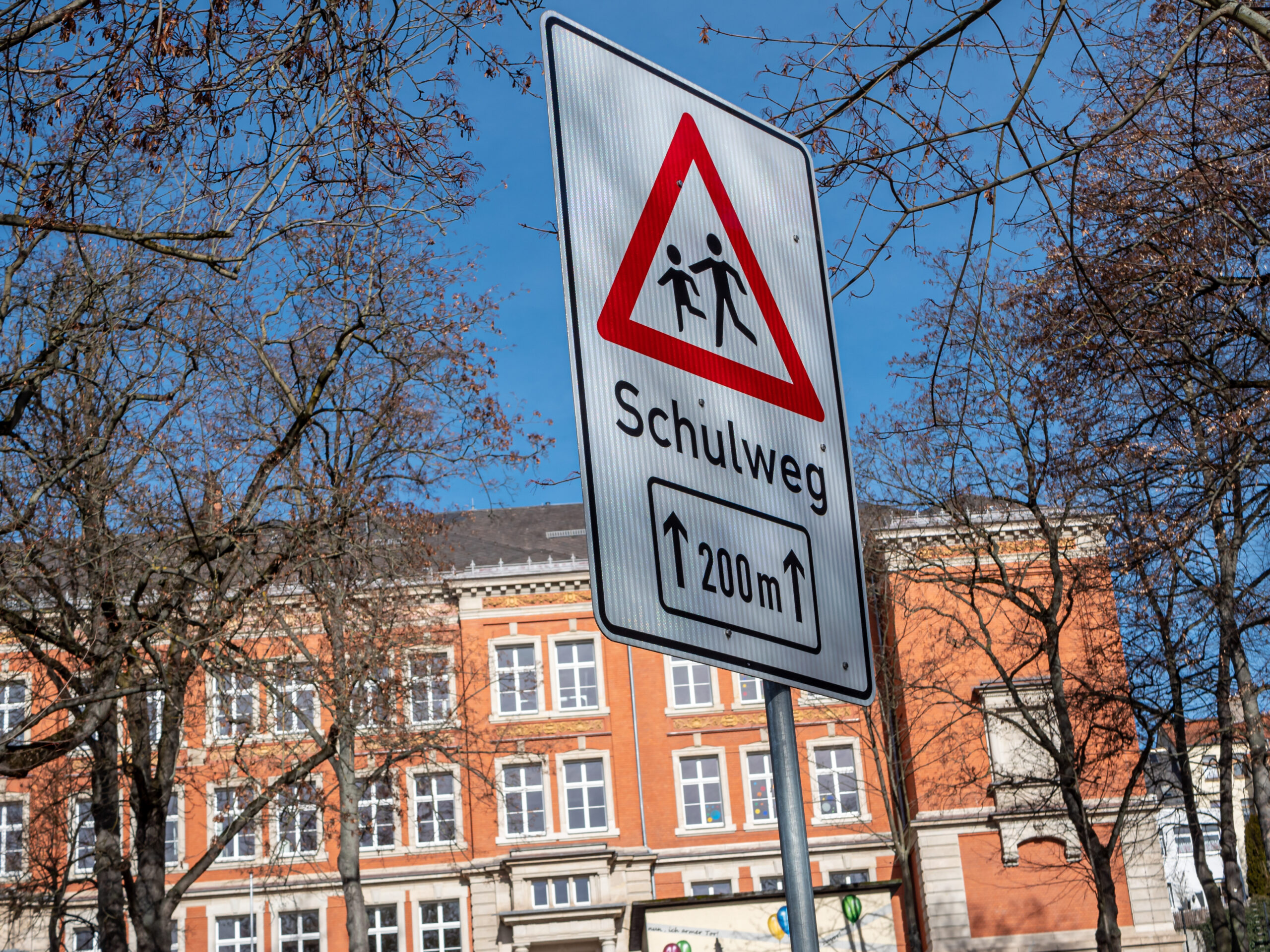 Das Bild zeigt ein Warnschild "Schulweg" am Straßenrand Das Bild zeigt ein Warnschild "Schulweg" am Straßenrand
